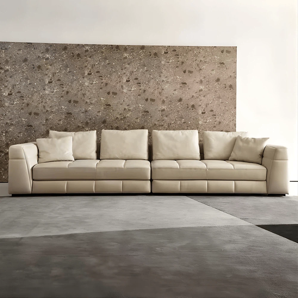 Cream leather modular sectional with deep seats and quilted stitching detail. Cream leather modular sectional with deep seats and quilted stitching detail.